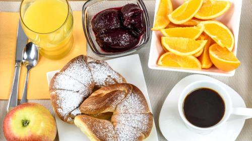 a table with bread and oranges and a cup of coffee at Pensiunea Casa Iorgovanul Urseni in Timişoara