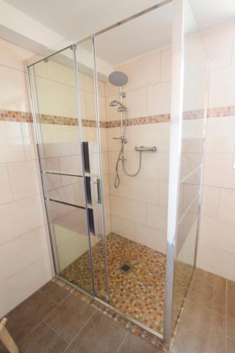 a shower with a glass door in a bathroom at Le Divin Gîte Classé 4 étoiles in Hunawihr