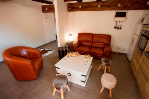 a living room with a leather couch and a table at Le Divin Gîte Classé 4 étoiles in Hunawihr