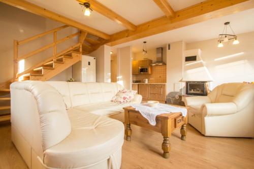 a living room with white furniture and a loft bed at Domek Osada Gubałówka Zakopane in Słodyczki