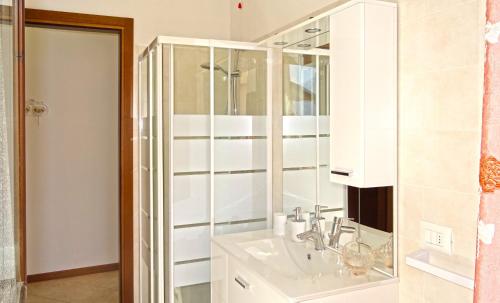 een witte badkamer met een wastafel en een douche bij La Quiete 27 Lake view by Gardadomusmea in Tremosine Sul Garda