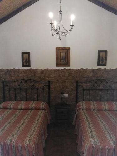 a bedroom with two beds and a chandelier at CASA EL CERRO in El Bosque