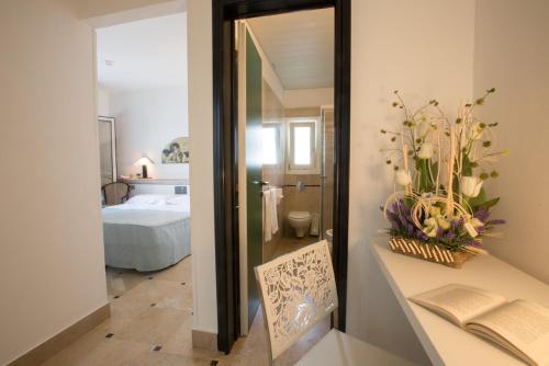 Zimmer mit einem Bett und einem Tisch mit einem Spiegel in der Unterkunft Hyencos Hotel Callyon in Torre San Giovanni Ugento