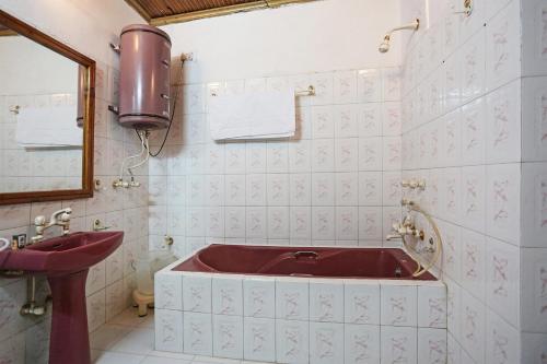 Un baño con una bañera roja y un lavabo. en Hotel Ashai, en Srinagar