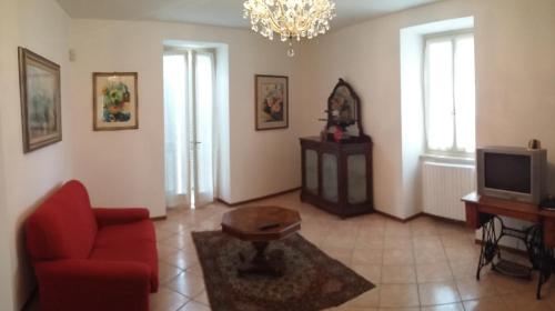 a living room with a red couch and a tv at Casa della Nonna 2 in Gargnano