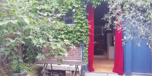 an open door with a bench in front of a house at Atelier d'artiste - Loft with garden center of Paris in Paris