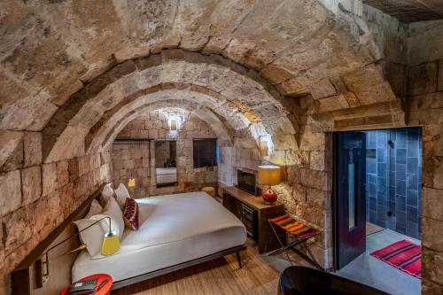 a room with a bed in a stone wall at Carus Cappadocia in Goreme