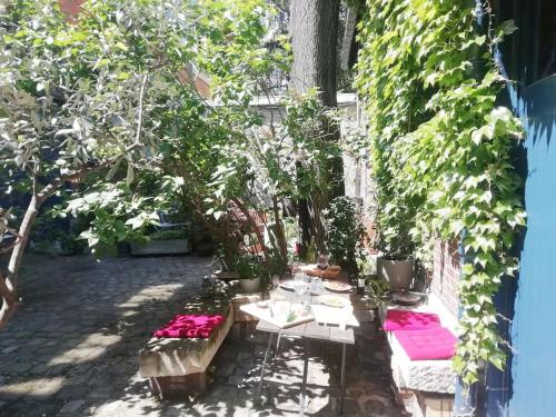 un patio con mesa, bancos y plantas en Atelier d'artiste - Loft with garden center of Paris en París