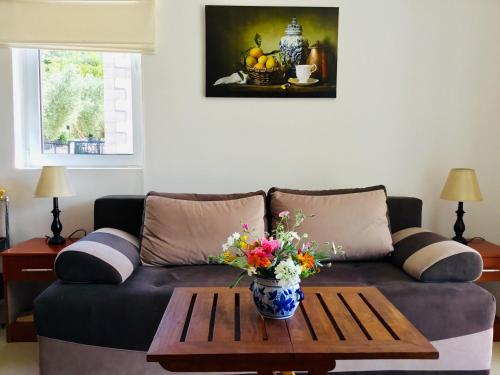 un soggiorno con divano e tavolo con fiori di Apartments Villa Lazic a Petrovac na Moru