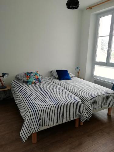 Ce lit se trouve dans un dortoir blanc doté d'une couverture rayée. dans l'établissement Appartement 5MN plages CANNES la Bocca, à Cannes