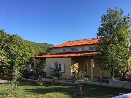 ein Haus mit einem orangenen Dach im Hof in der Unterkunft Dee's House and Pool in Labin