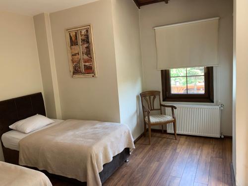 サパンジャにあるTüreyen Villaları Sapanca 1のベッドルーム1室(ベッド2台、窓、椅子付)