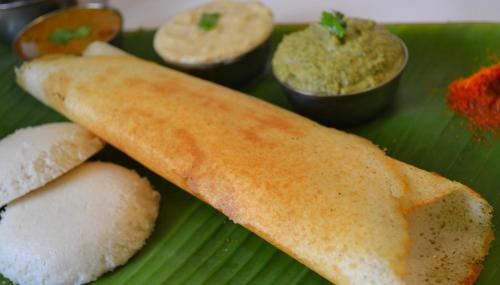 a green plate with a piece of bread and some dips at Samsan Residentia in Visakhapatnam