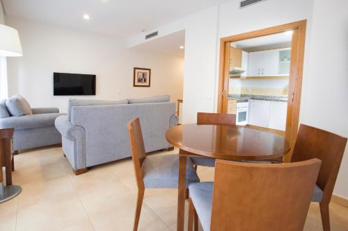 a living room with a table and a couch at Aparthotel Albufera in Alfafar