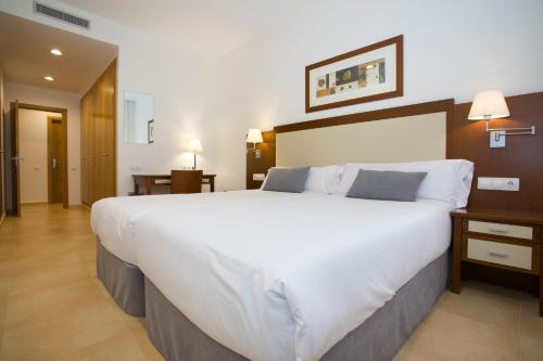 a large white bed in a hotel room at Aparthotel Albufera in Alfafar
