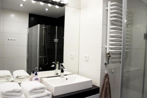 Baño blanco con lavabo y espejo en Apartament Stawowa, en Cieszyn