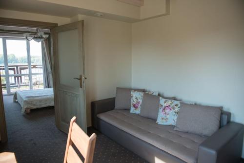 a living room with a couch and a balcony at Apartamenty Faust in Ełk