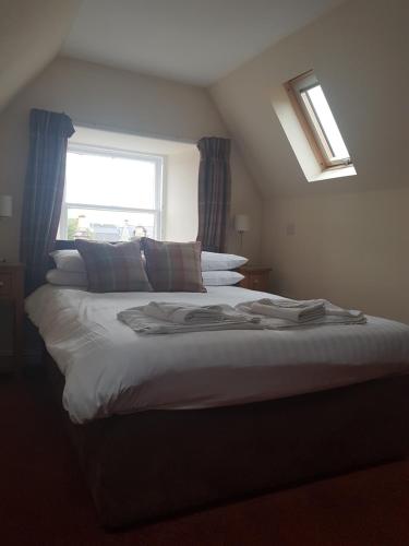 a bedroom with a large bed with a window at The Station Hotel in Alness