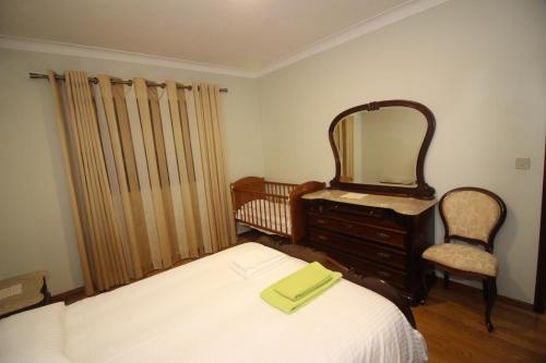 a bedroom with a bed and a mirror and a chair at Casa Bela Vista by Gerês Casas in Geres