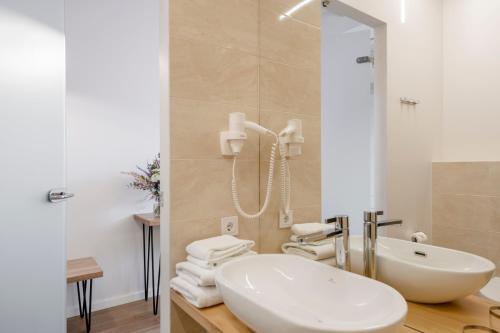 a white bathroom with a sink and a shower at Vilnius Apartments in Vilnius