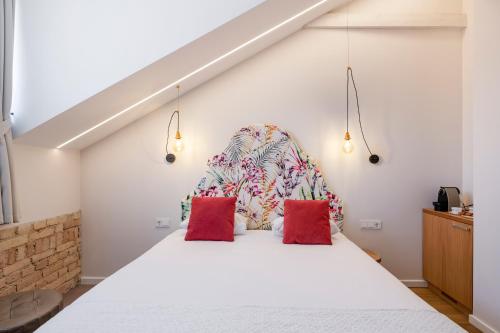 a bedroom with a large white bed with red pillows at Vilnius Apartments in Vilnius