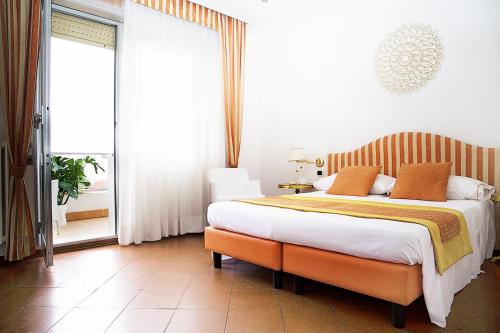 una camera da letto con un letto grande e una grande finestra di Hotel Iva a Diano Marina
