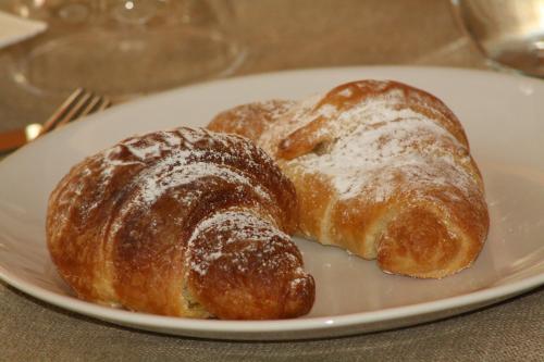 two pastries on a white plate on a table at Il Principe B&B in Ali Terme