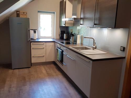 a kitchen with a sink and a refrigerator at Ferienhaus an der Sesselbahn in Cochem