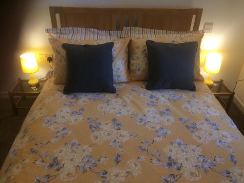 a bed with blue and white sheets and pillows at Crossgates, Rosehearty in Rosehearty