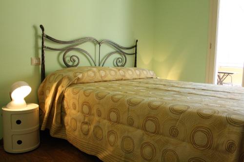 a bedroom with a bed and a lamp on the floor at Il Principe B&B in Alì Terme