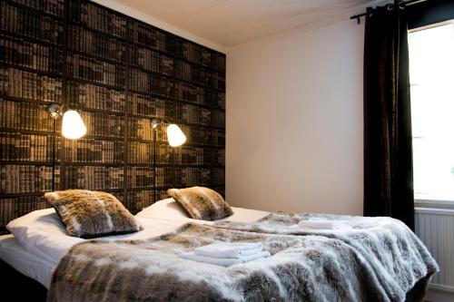 a bedroom with a large bed with a wall of books at Marsfjäll Mountain Lodge Hotell i Saxnäs in Saxnäs