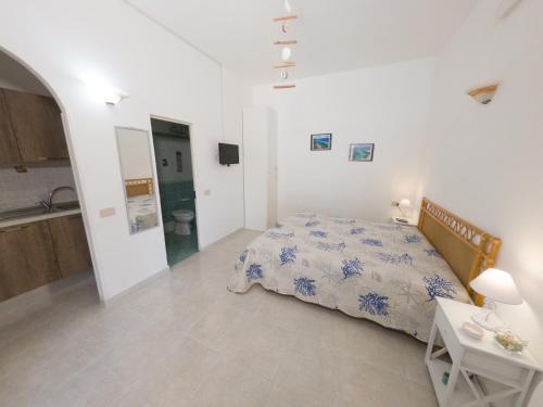 a white bedroom with a bed and a sink at Il corallo rosso in Favignana