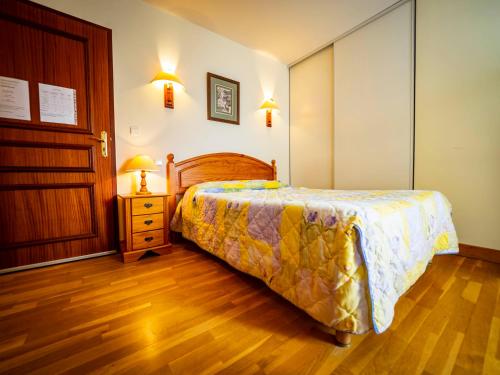 a bedroom with a bed and a wooden floor at Achafla Baita in Ascain