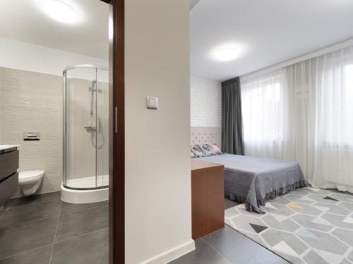 a bathroom with a bed and a shower and a toilet at Apartamenty Faust in Ełk