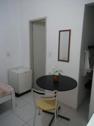 a room with a table and two chairs and a mirror at Studio 51 residence in Recife