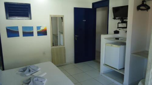 a small kitchen with a blue door and a sink at Hotel Praia do Futuro in Fortaleza