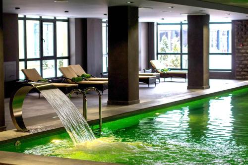 キスロヴォツクにあるGreen Resort Hotel and SPAのホテルロビーの噴水付きスイミングプール