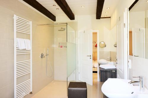 ein Bad mit einer Dusche und einem Waschbecken in der Unterkunft Apartments Lille Hus in Sankt Peter-Ording