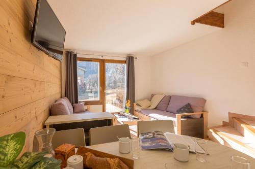 un salon avec une table et un canapé dans l'établissement Les Chalets du Jardin Alpin, à La Salle Les Alpes