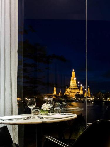 a table with wine glasses on top of a window at Sala Rattanakosin Bangkok in Bangkok