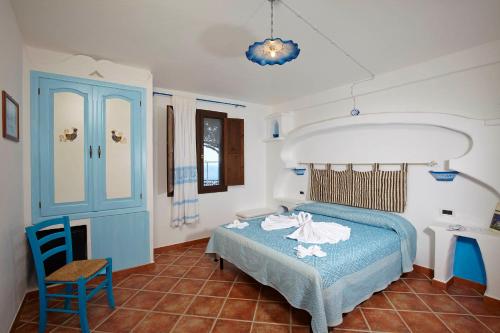 a bedroom with a blue bed and a chair at Agriturismo Codula Fuili in Cala Gonone