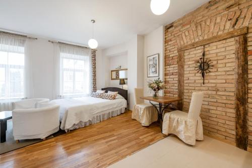 a bedroom with a bed and a brick wall at Vilnius Apartments in Vilnius