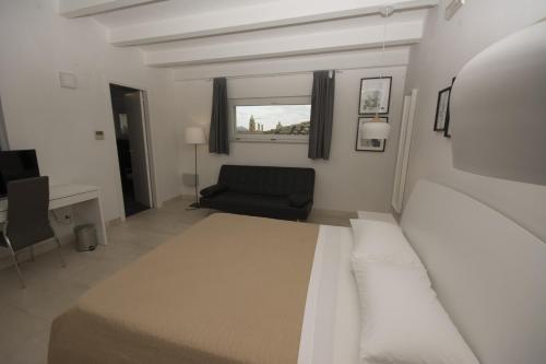 a bedroom with a bed and a chair and a window at Palazzo di Fazio Suites in San Severo
