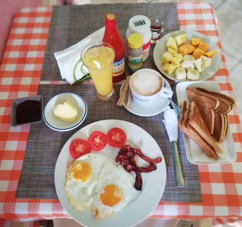a breakfast plate with eggs bacon tomatoes and toast at Parco del Caribe in Boca Chica