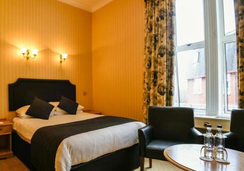 a hotel room with a bed and a table and chairs at Cairndale Hotel & Spa in Dumfries