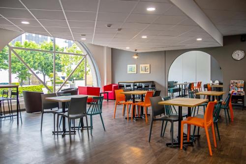 une salle à manger avec des tables et des chaises dans un restaurant dans l'établissement hotelF1 Cergy, à Cergy