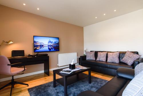 a living room with a couch and a tv on a wall at Oakfield Premier Apartments-High Speed WiFi-Smart SelfCheckIn-Central Cardiff Gem in Cardiff