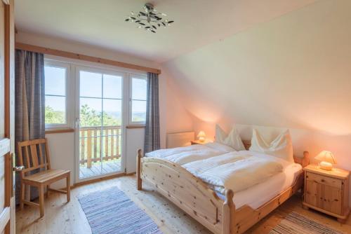 a bedroom with a bed and a large window at Bio-Hof Windhaber in Stubenberg