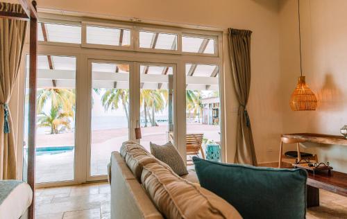a living room with a couch and a sliding glass door at The Lodge at Jaguar Reef in Hopkins