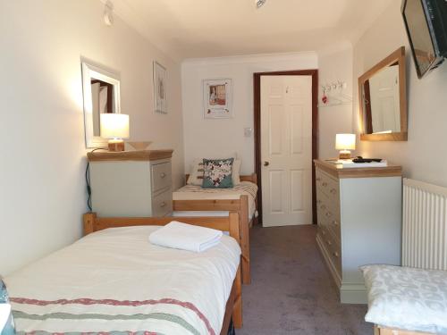 een slaapkamer met een bed en een dressoir met 2 lampen bij Lyndale Family Apt Winter Deals offered on 3 nts or more in Windermere
